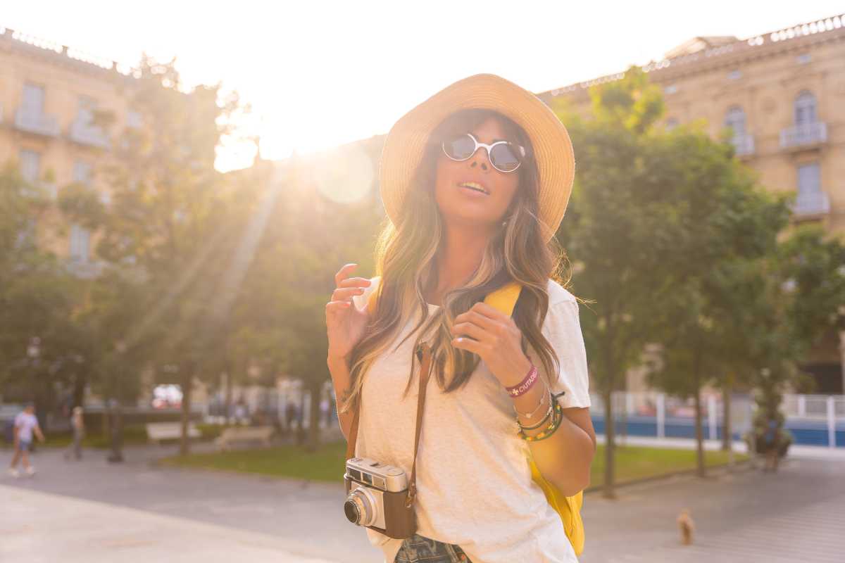 una donna con cappello visita una città in estate