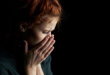 una donna si porta le mani al volto per disperazione