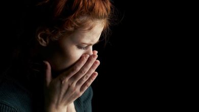 una donna si porta le mani al volto per disperazione