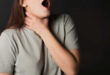 donna che si tiene la gola con una mano perché sta avendo uno shock anafilattico per grave allergia