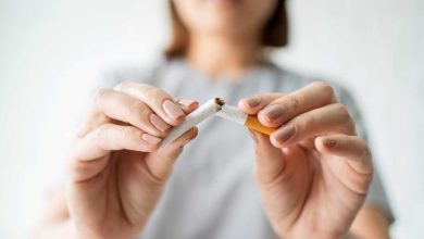 primo piano di una donna che spezza in due una sigaretta