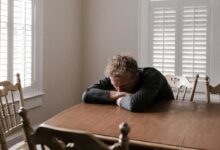 uomo confuso seduto al tavolo con segnali di alzheimer