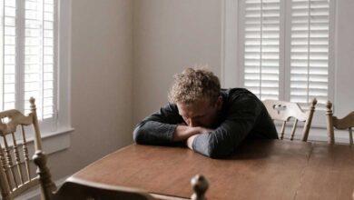uomo confuso seduto al tavolo con segnali di alzheimer