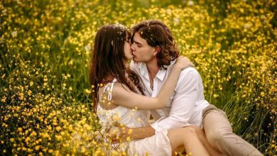 un ragazzo e una ragazza si baciano in un campo fiorito