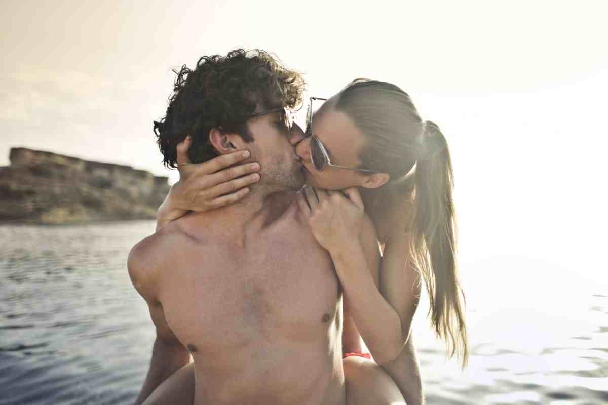 un ragazzo e una ragazza si baciano al mare