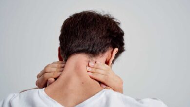 uomo con meningite che si tocca il collo perché ha rigidità nucale