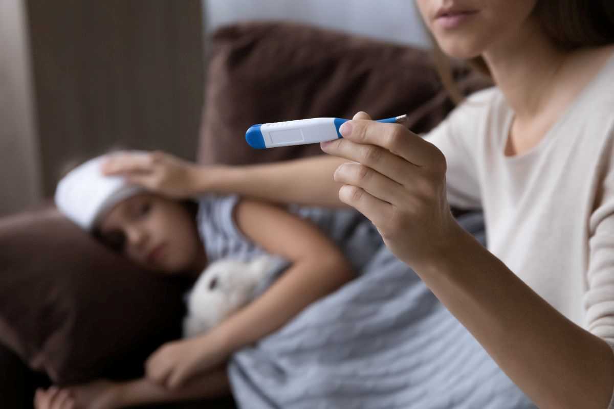 mamma che prova la febbre alla figlia