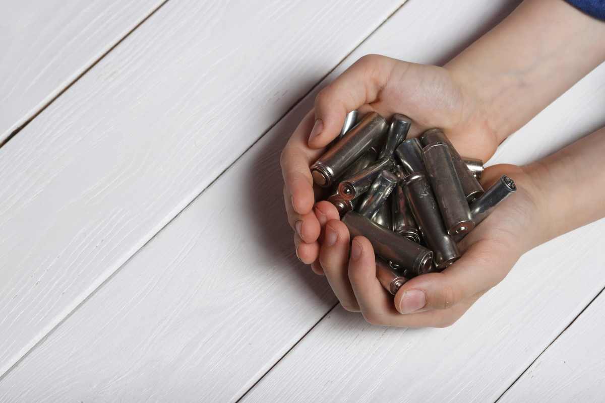 un ragazzino con in mano i piccoli contenitori di gas esilarante
