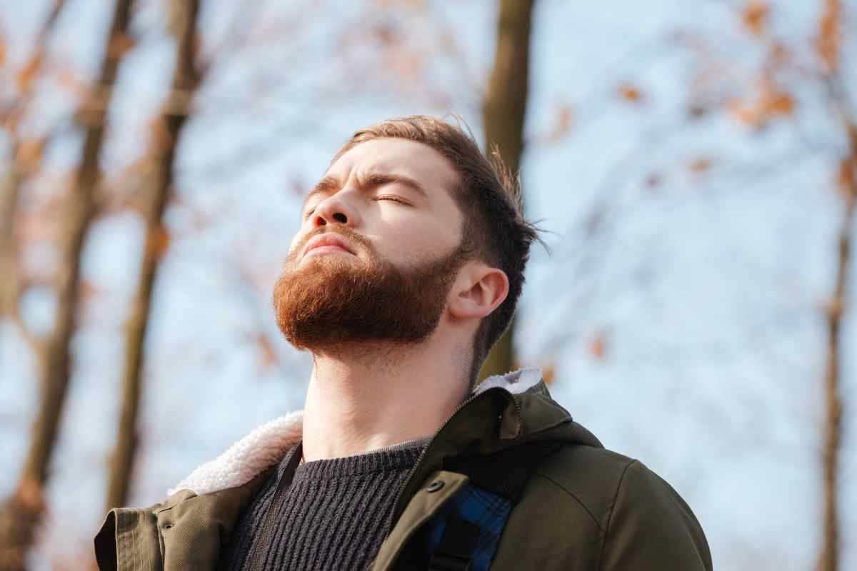 un ragazzo si ferma a respirare mentre passeggia in un parco