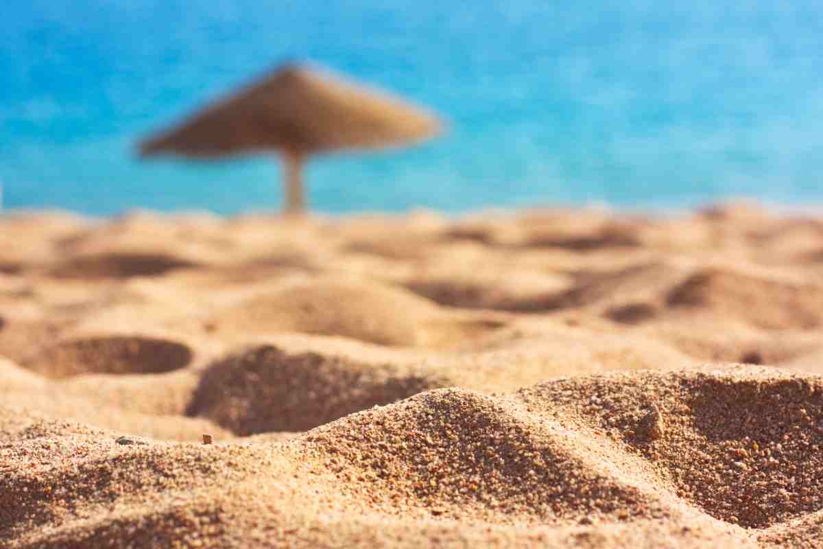 spiaggia con un ombrellone di paglia