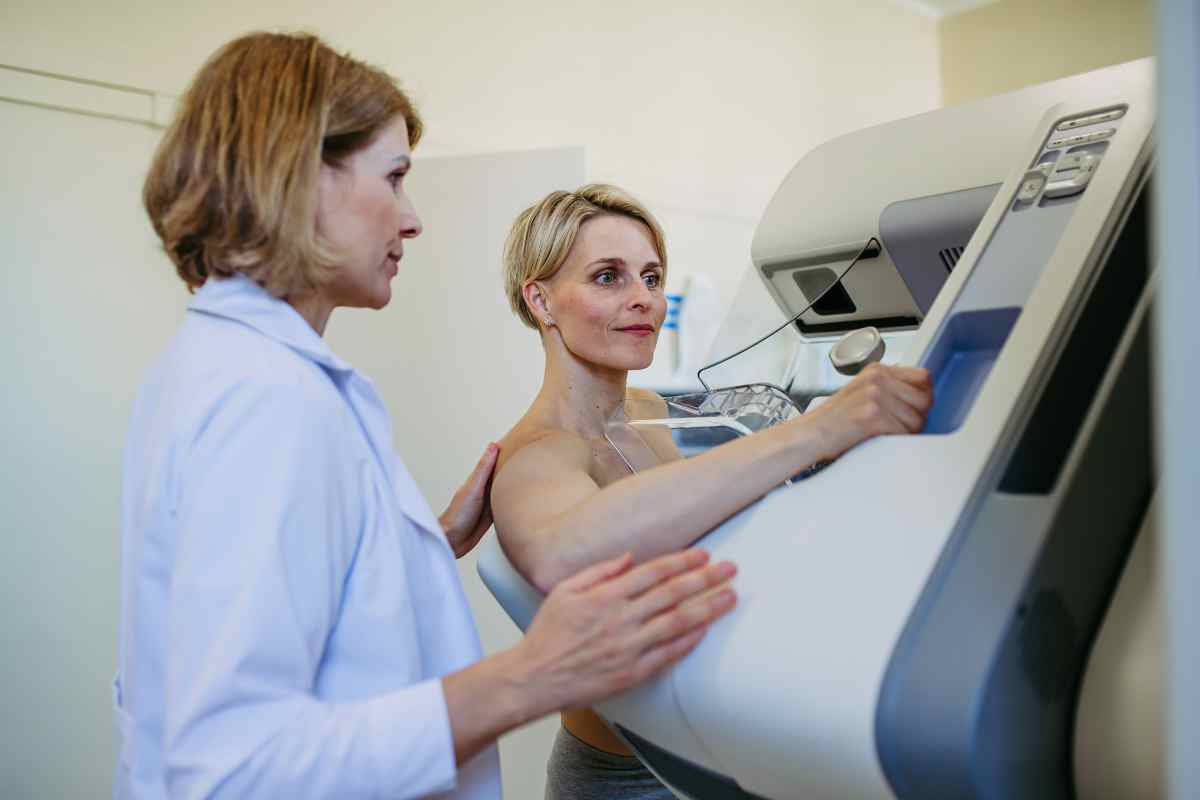 una paziente si sottopone alla mammografia sotto la guida dell'ecografa