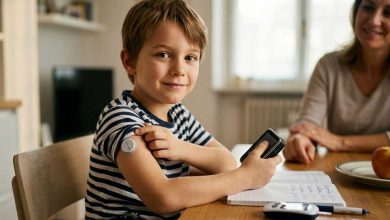 bambino seduto alla scrivania mentre indossa il dispositivo per il monitoraggio del diabete di tipo 1
