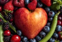 immagine con una mela a forma di cuore circondata da frutti rossi e fave fresche