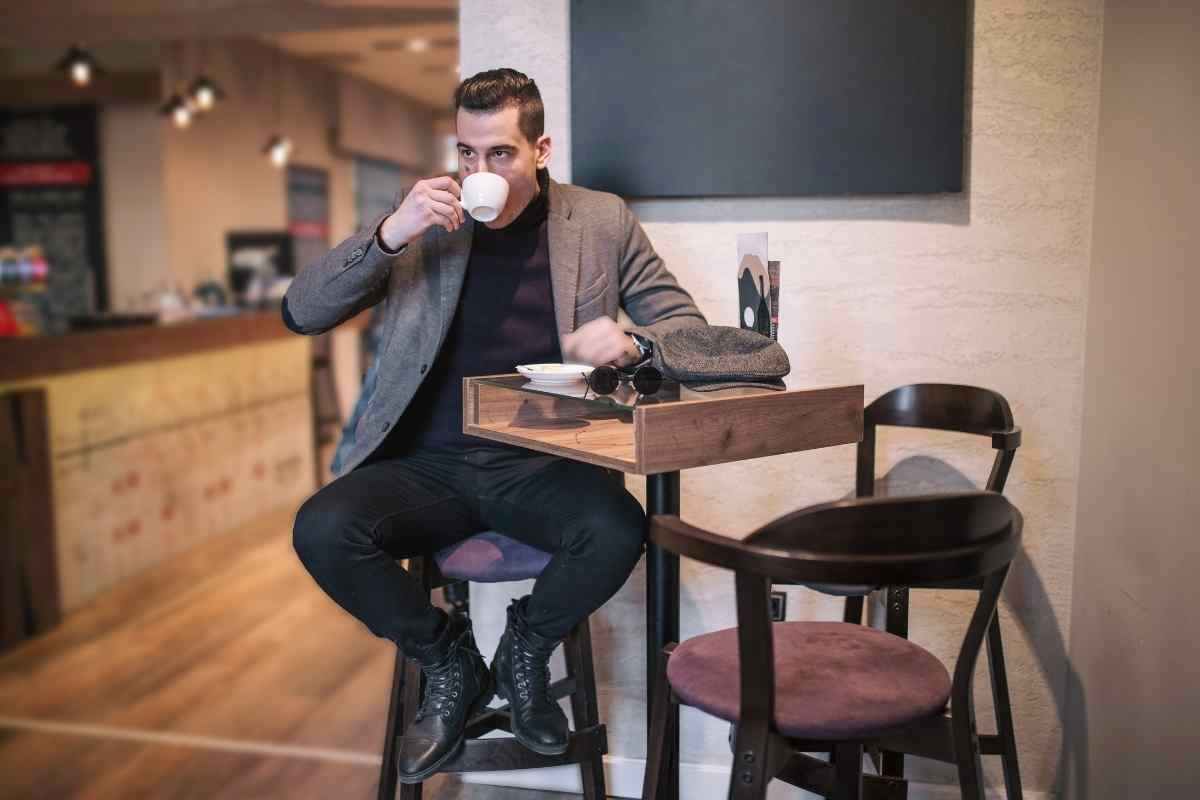 un uomo beve un caffè in un bar