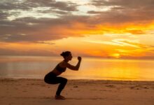 ragazza che fa gli squat sulla spiaggia, in riva al mare