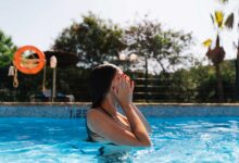 donna in piscina che si mette le mani sugli occhi