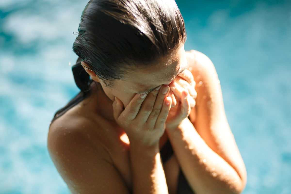ragazza che si gratta gli occhi dopo essere uscita dalla piscina