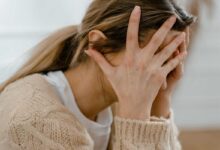 donna con conflitto interiore si porta le mani alla testa simbolo di quanto sia pericoloso il metodo hamer