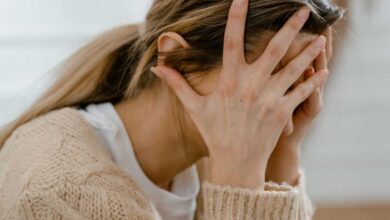 donna con conflitto interiore si porta le mani alla testa simbolo di quanto sia pericoloso il metodo hamer