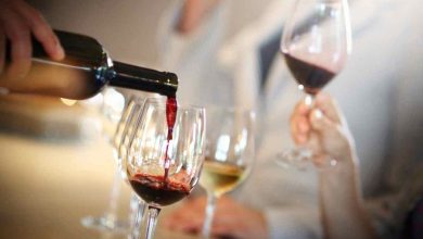 una persona versa vino in diversi bicchieri
