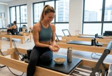 ragazza che ha finito l'allenamento di reformer pilates e mangia pistacchi americani