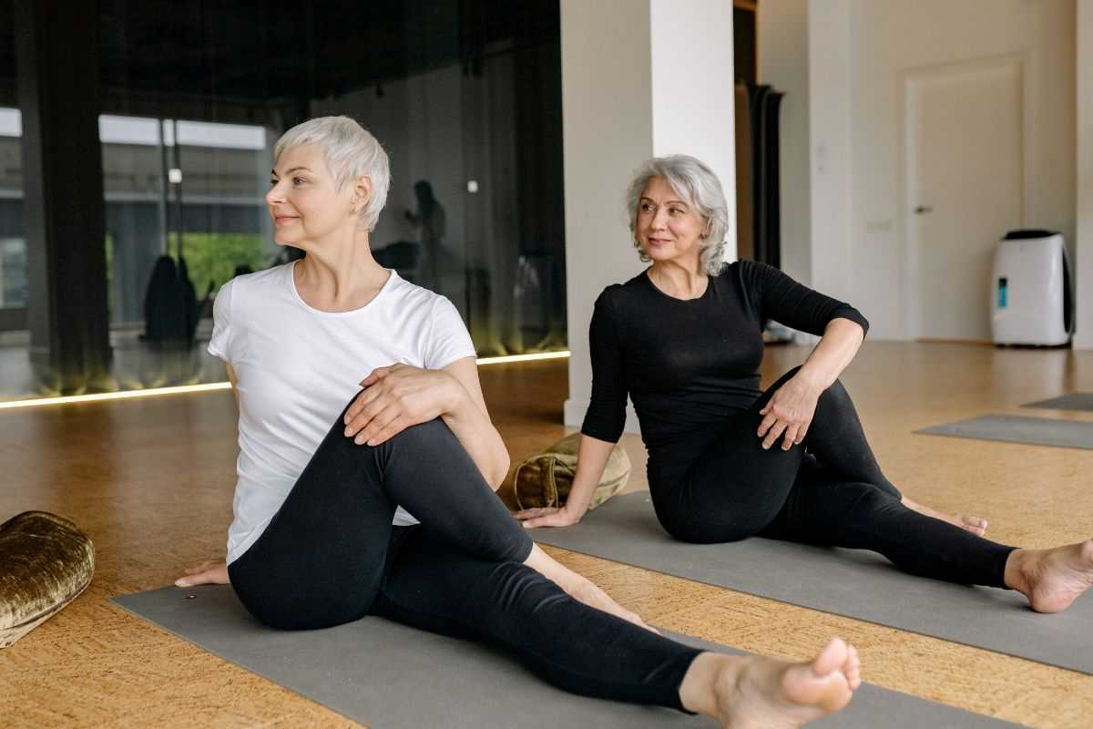 due donne over 60 che fanno attività fisica moderata come il pilates sul materassino