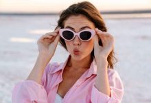 una ragazza indossa occhiali da sole in spiaggia