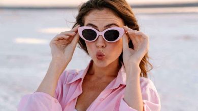 una ragazza indossa occhiali da sole in spiaggia