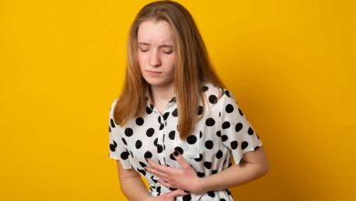 una donna si porta le mani all'altezza dello stomaco