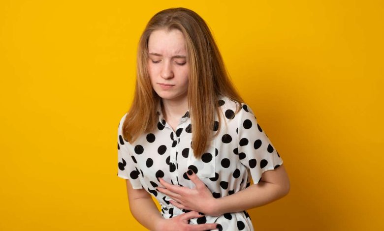 una donna si porta le mani all'altezza dello stomaco