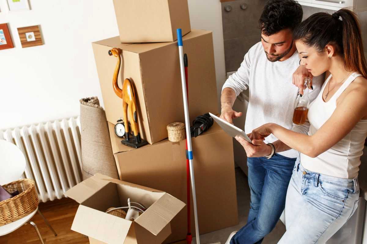 coppia che controlla la checklist degli scatoloni mentre fanno trasloco