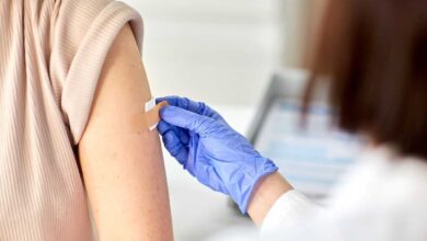 dottoressa che mette un cerotto sul braccio di una donna che si è appena sottoposta a vaccinazione in estate