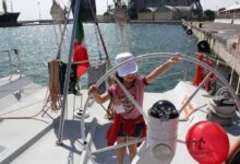 bambina a bordo di una barca a vela per il progetto sognando itaca promosso da AIL per tumori del sangue