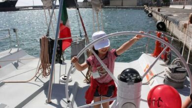 bambina a bordo di una barca a vela per il progetto sognando itaca promosso da AIL per tumori del sangue