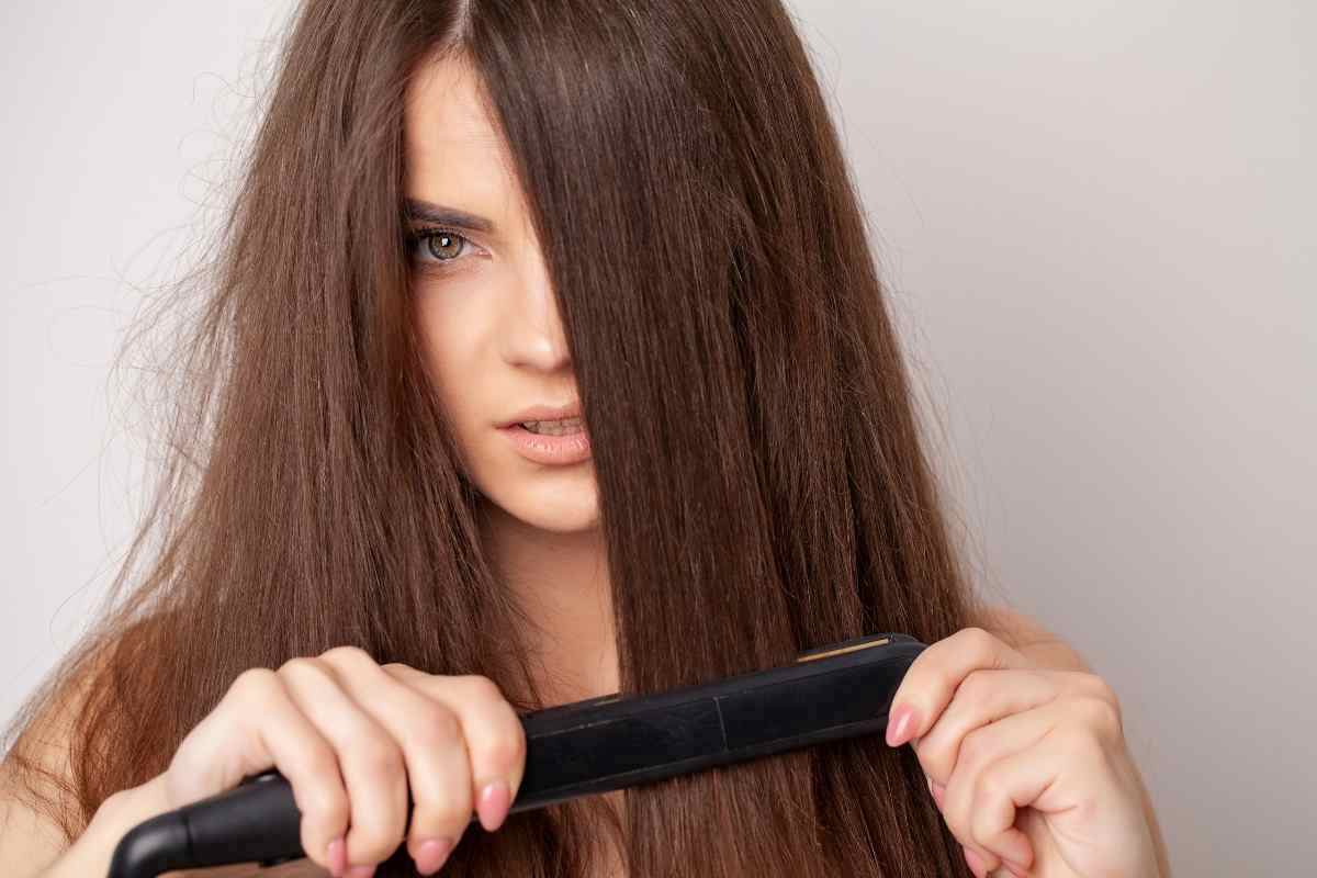 una ragazza si piastra i capelli