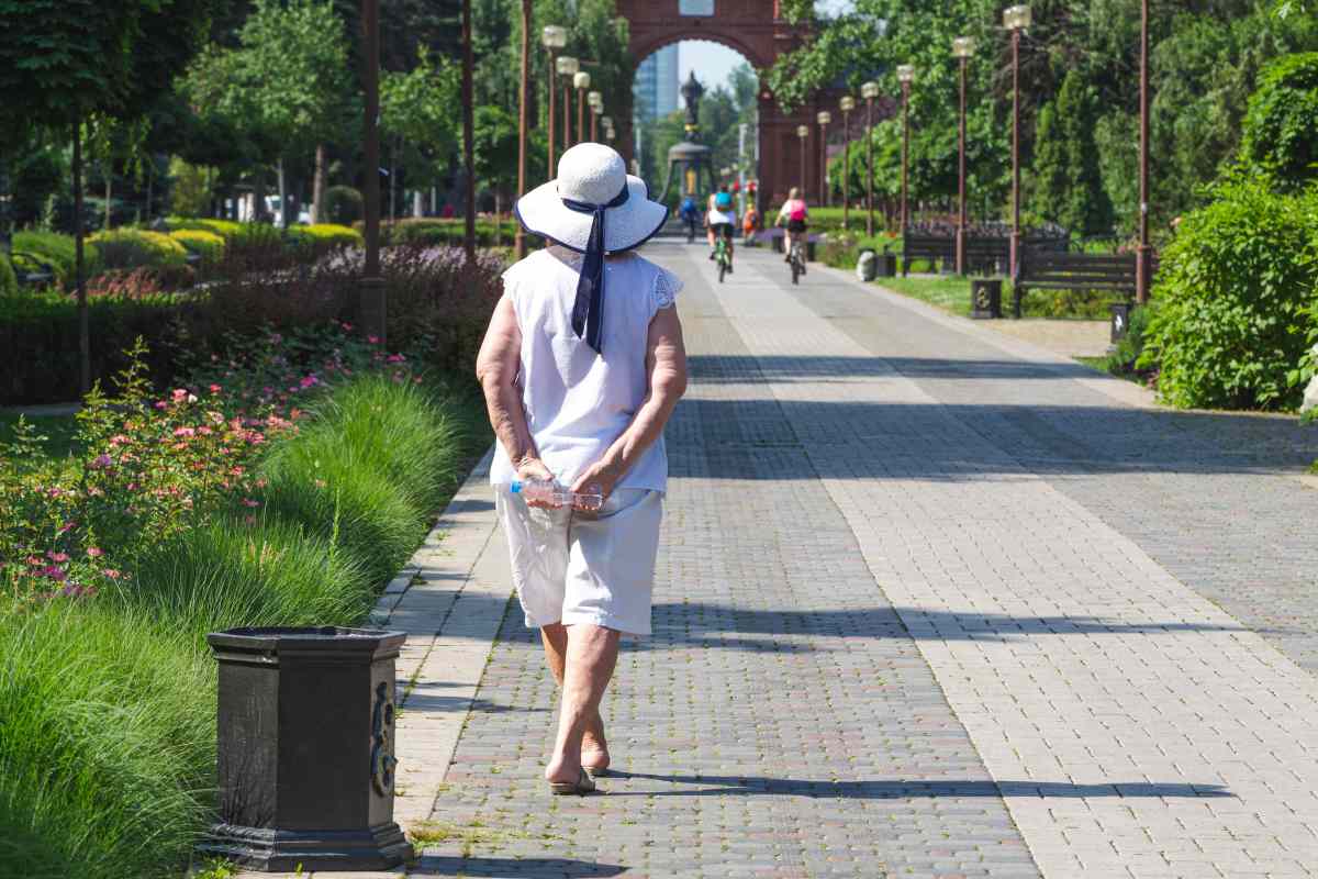 una donna anziana cammina in mezzo al verde