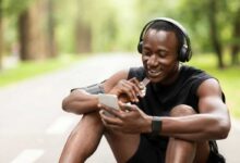 ragazzo seduto in terra che fa una pausa mangiando una barretta energetica dopo aver fatto sport