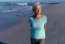 una donna matura cammina sulla spiaggia