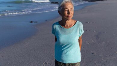 una donna matura cammina sulla spiaggia