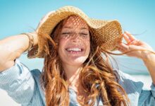 donna sotto al sole che muove i capelli