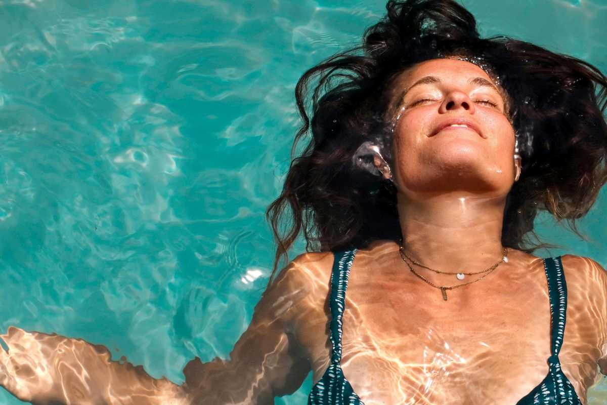donna immersa con i capelli in piscina