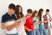 un gruppo di adolescenti con gli occhi fissi su uno smartphone