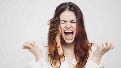 una donna con una spazzola tra i capelli grida