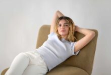 giusy buscemi posa per il fotografo piergiorgio pirrone, sdraiata su una poltroncina e indossando tshirt azzurra e pantalone bianco