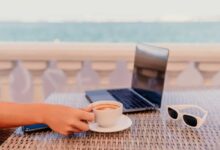 donna che lavora in vacanza da una terrazza che affaccia sul mare