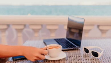 donna che lavora in vacanza da una terrazza che affaccia sul mare