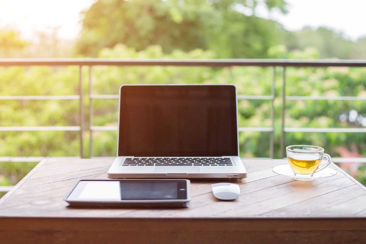 postazione di lavoro con computer, mouse e tablet davanti alla natura