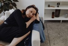 donna triste e pensierosa sdraiata sul divano