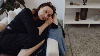 donna triste e pensierosa sdraiata sul divano