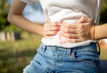 donna che si appoggia le mani sulla pancia perché ha alterazioni del microbiota in estate